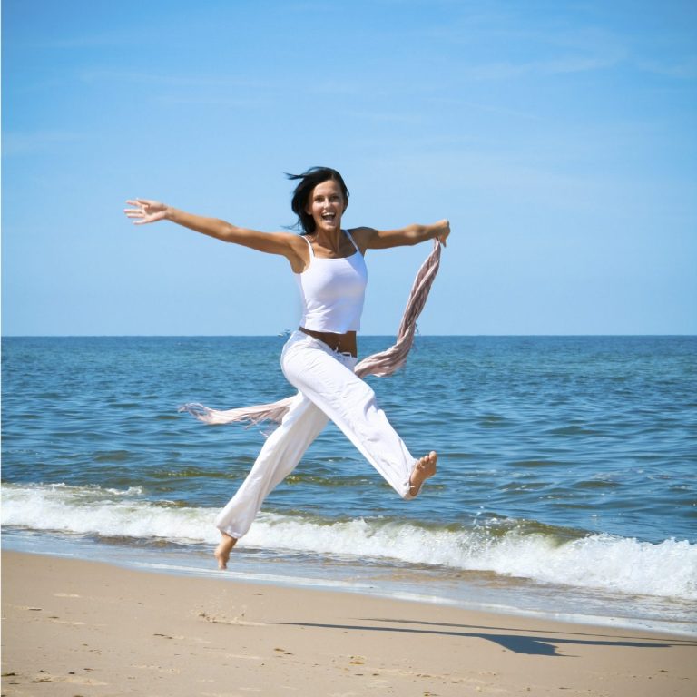 Frau hüpft am Strand